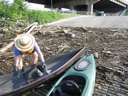 The Wife Complains Bitterly As She Hauls Her Canoe Across Accumulated Debris At The Albany Boat Launch